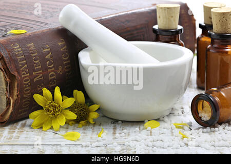 Arnica homéopathique comprimés dans des flacons en verre brun sur table en bois Banque D'Images