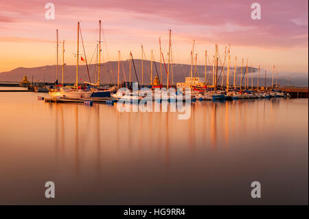 Bateaux à voile amarré dans une marina à Reykjavik, Islande, panier par le soleil de minuit. Banque D'Images