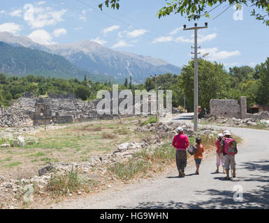 Tlos, Province d''Antalya, Turquie. Ruines de la ville antique. Enfants sur route en face du théâtre datant de l'époque romaine. Banque D'Images