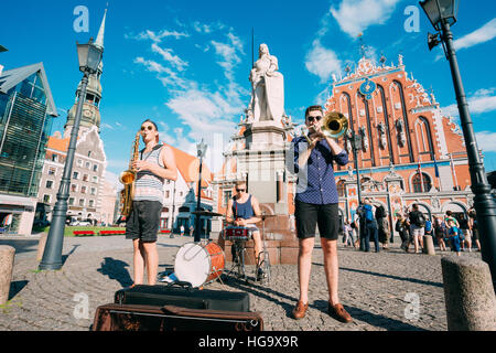 Riga, Lettonie - 1 juillet 2016 : Street Music Trio Groupe de trois jeunes musiciens gars jouant les instruments pour le don sur la place de l'hôtel de ville, célèbre Banque D'Images