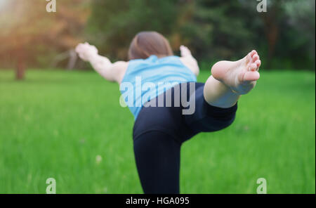 Close-up de la jambe d'une jeune fille qui pratique le yoga dans la nature. Elle équilibre sur une jambe. Banque D'Images