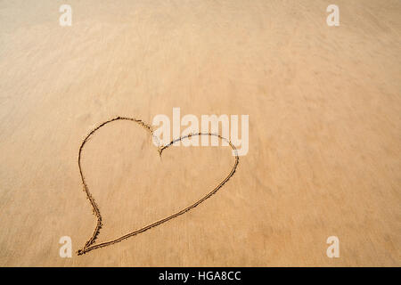 Coeur dessiné dans le sable plage lisse pour célébrer la Saint-Valentin romantique Banque D'Images