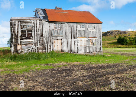 Vieux et abandonné maison en bois avec toit rouge dans la campagne norvégienne Banque D'Images