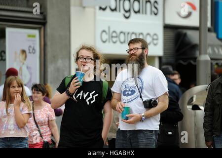 Adolescente et l'homme d'âge moyen en regardant les musiciens sur la lande Sheffield, prenant part à l'Jalonnages Fringe Festival 2014 Banque D'Images