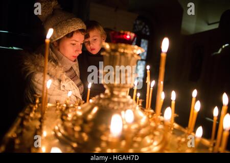 Moscou, Russie. Jan 7, 2017. La femme et son enfant allumer une bougie au cours de l'culte de Noël à Moscou, Russie, le 7 janvier 2017. Le Jour de noël est célébré par les Chrétiens orthodoxes le 7 janvier. © Evgeny Sinitsyn/Xinhua/Alamy Live News Banque D'Images