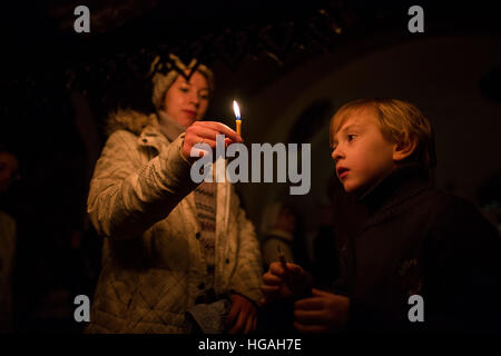 Moscou, Russie. Jan 7, 2017. Une femme donne une bougie pour un garçon pendant la culte de Noël à Moscou, Russie, le 7 janvier 2017. Le Jour de noël est célébré par les Chrétiens orthodoxes le 7 janvier. © Evgeny Sinitsyn/Xinhua/Alamy Live News Banque D'Images