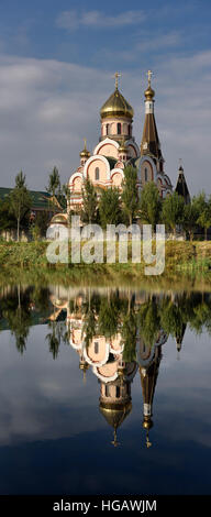 Panorama vertical de l'église de l'Exaltation de la Sainte Croix à Almaty Kazakhstan reflète dans le lac encore Banque D'Images