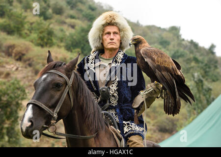 Formateur d'oiseaux à cheval tenant un aigle doré au Kazakhstan Almaty Sunkar Raptor Center Banque D'Images