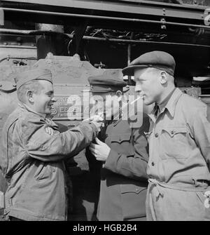 Un sergent américain cheminot allumer la cigarette de deux ingénieurs du chemin de fer russe, 1943. Banque D'Images