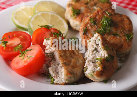 Délicieux gâteau de poisson frit avec des herbes sur une assiette blanche horizontale. Banque D'Images