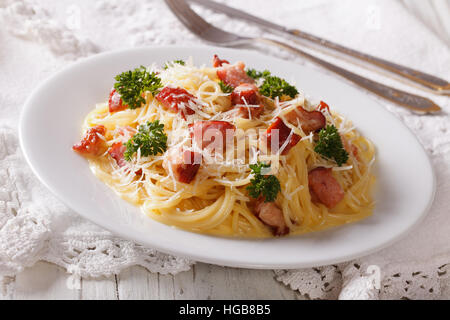 Les pâtes italiennes carbonara avec bacon et parmesan close-up sur une plaque horizontale. Banque D'Images