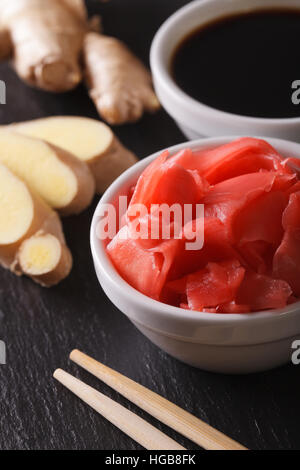 Gingembre mariné et la sauce soja dans un bol macro sur la table verticale. Banque D'Images