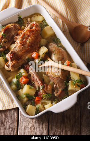 Ragoût de poulet fait maison avec des pommes de terre, les courgettes et les carottes dans un plat close-up vertical Vue de dessus. Banque D'Images