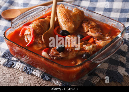 Braisé de poulet savoureux en sauce tomate aux olives et le poivre dans un bol en verre de près. L'horizontale Banque D'Images