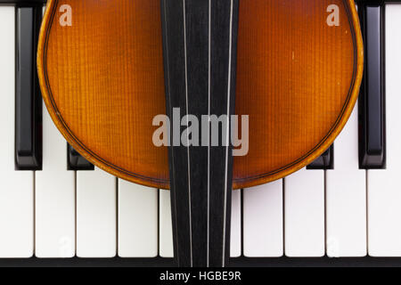 Très ancien violon couché sur le piano Banque D'Images