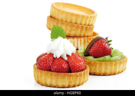 Mini tortes rempli de tranches de kiwi et de fraise, recouvert de crème fouettée Banque D'Images