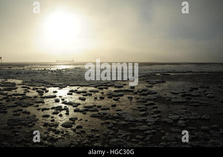 Étendue de glace de mer sur le sable à marée basse vers le blanc soleil qui brille au-dessus de couleurs vives, jetée steamer Beach au nord de la jetée, St Annes, UK Banque D'Images