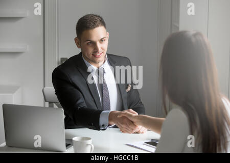 Businessman and businesswoman shaking hands en accord Banque D'Images