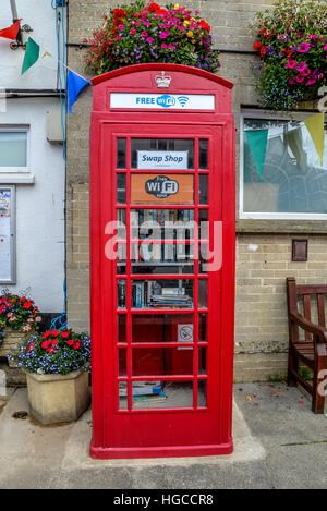 Vieux téléphone rouge fort maintenant utilisé comme un livre d'échange avec une connexion Wi-Fi gratuite disponible dans l'ouest du Devon UK Pays de la bière Banque D'Images