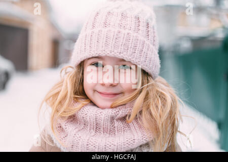 Portrait d'hiver enfant sourire girl in hat and scarf Banque D'Images