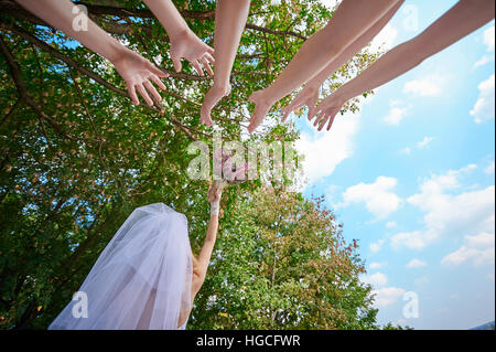 Mariée lance le bouquet de mariage pour les jeunes femmes Banque D'Images