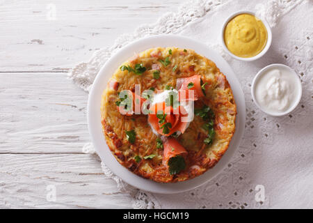 Galettes de pommes de terre avec le saumon fumé et la sauce sur une assiette. Vue supérieure horizontale Banque D'Images