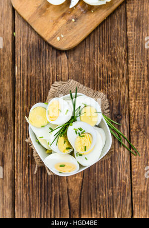 Table en bois avec les oeufs coupés en deux (selective focus ; close-up shot) Banque D'Images