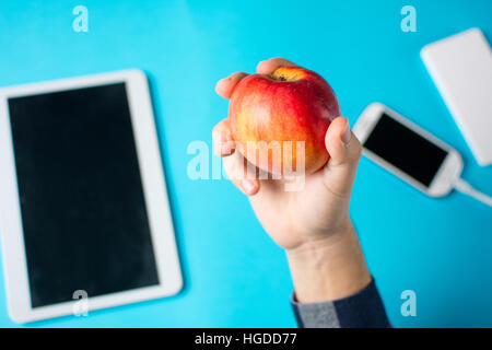 Homme de main tenant une pomme à l'œuvre dans le bureau Banque D'Images