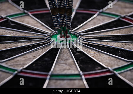 Trois flèches dart dans le centre de frapper la cible de fléchettes Banque D'Images