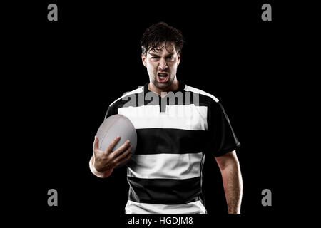 Joueur de Rugby dans un uniforme noir et blanc. Fond noir. Banque D'Images