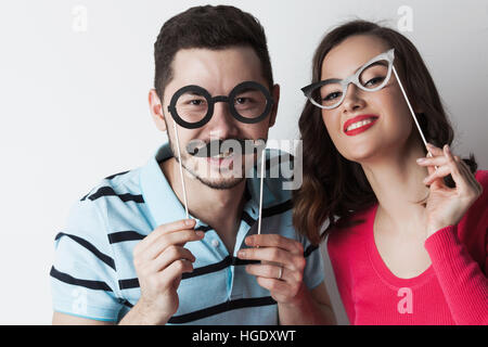 Drôle de couple holding partie lunettes et moustaches sur bois Banque D'Images