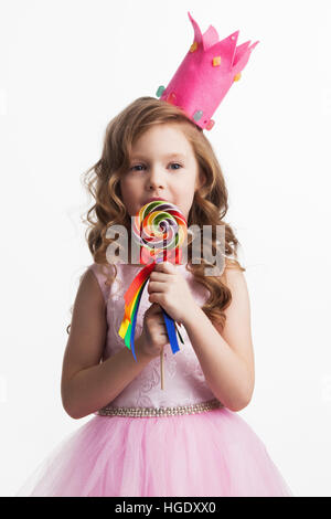 Belle petite princesse candy girl in crown holding big lollipop isolated on white Banque D'Images