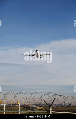 Un avion de passagers en vol au dessus de la barrière de sécurité dans l'aéroport de Stuttgart à Stuttgart, Allemagne. Banque D'Images