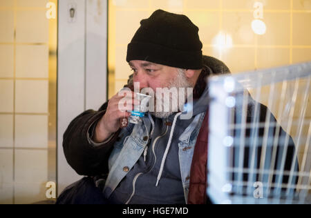 Munich, Allemagne. 06 Jan, 2017. L'homme sans foyer Ben buvant un café que lui a donné une mission dans la ville bus à son endroit pour dormir dans un grand magasin durant des températures de moins-neuf degrés à Munich, Allemagne, 06 janvier 2017. Les supporteurs bénévoles du 'Kaeltebusses'(lt. Les autobus à froid) en voiture à la réunion et de places de couchage des personnes sans-abri la nuit pour leur donner les aliments chauds et les boissons à apporter un certain soulagement sur les nuits froides. Photo : Matthias Balk/dpa/Alamy Live News Banque D'Images