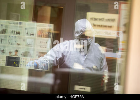 Duisburg, Allemagne. Le 08 Jan, 2017. Membre de l'équipe d'enquête criminelle des traces de fixation à l'entrée de la station de police de Rheinhausen à Duisburg, Allemagne, 08 janvier 2017. À la station de police précédemment abattu un homme armé d'un couteau. Selon le bureau du procureur d'Etat, un homme d'âge moyen est entré dans la gare à Rheinhausen peu avant minuit le samedi, sortit un couteau et a ensuite été tué par plusieurs coups d'une arme de la police. Photo : Christoph Reichwein/dpa/Alamy Live News Banque D'Images