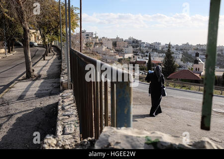 Jérusalem, Israël. 9 janvier, 2017. Une femme palestinienne promenades à travers l'ouverture et la surveillance de l'onu-passage entre le quartier palestinien de Jabel Mukaber (à droite) et le quartier juif de Armon Hanatziv (à gauche) sur le matin après un éperonnage camion liés à la terreur. Quatre soldats ont été tués et 17 blessés, lorsqu'un camion conduit par un terroriste arabe israélien imposé dans un groupe de soldats à côté de l'Armon Hanatziv promenade à Jérusalem le dimanche après-midi, le 8 janvier, 2017. L'attaquant, tué sur les lieux, 28 ans Fadi Qunbar, le père de quatre, à partir de la peuple palestinien Banque D'Images