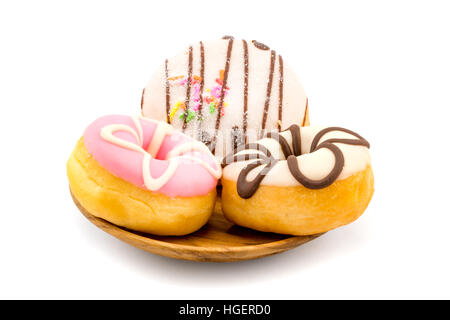 Délicieux donuts colorés dans la plaque en bois sur fond blanc Banque D'Images