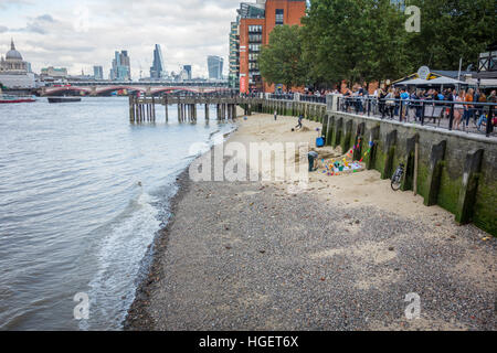 Les personnes faisant des sculptures de sable sur la plage créé par marée basse sur la Tamise près de la tour Oxo, Southbank, Londres, UK Banque D'Images