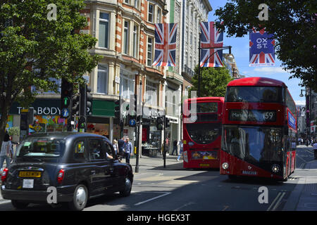 Oxford Street, Londres en été. La rue est décorée avec des drapeaux Union Jack et un bus rouge et des taxis noirs se déplaçant dans la rue. Banque D'Images