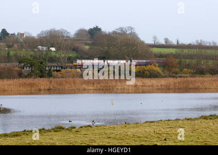 Un train sur la ligne 'Avocette d' passe la RSPB Bowling Green, Topsham, Devon, UK Banque D'Images