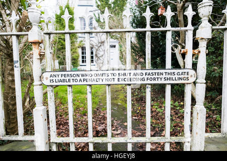 13 Un panneau d'avertissement ferroviaire LNER "Toute personne qui omet d'arrêter et de fixer cette porte est passible d'une amende n'excédant pas quarante deniers sur la porte d'une maison à Llanfyllin, Powys Pays de Galles UK Banque D'Images