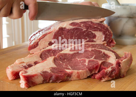 Couper le boeuf frais faux-filets de boeuf sur une planche à découper en bois Banque D'Images