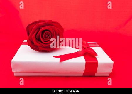 Boîte cadeau Saint Valentin avec un arc rouge sur fond rouge. Image du Jour de Valentines. Banque D'Images