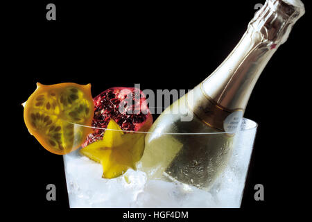 Bouteille de champagne et fruits dans un refroidisseur à champagne Banque D'Images