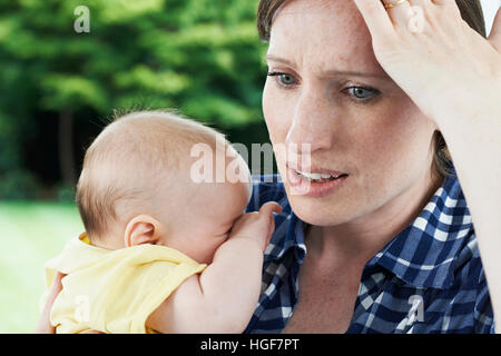 Oublieux Mother Holding Baby Girl at Home Banque D'Images