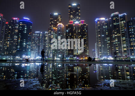 Gratte-ciel à Marine City quartier résidentiel dans le quartier de Haeundae et leur reflet dans une flaque à Busan, Corée du Sud dans la nuit Banque D'Images