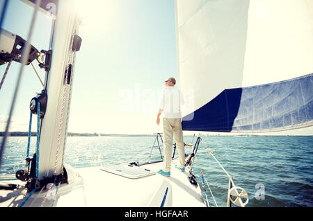 Senior man on naviguer bateau ou yacht voile en mer Banque D'Images