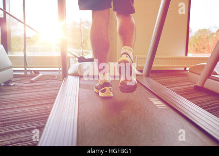 Close up of man jambes marche sur tapis roulant dans une salle de sport Banque D'Images