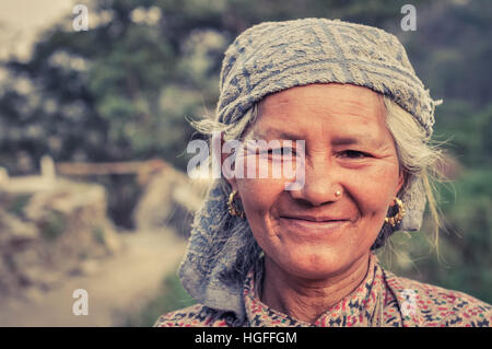 Beni, le Népal - circa Mai 2012 : gris natif-haired woman avec headcloth et anneaux d'or et de piercing sourit gentiment de photocamera à Beni, le Népal. N Banque D'Images