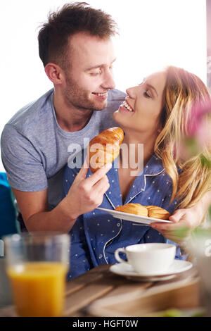 Copain copine d'alimentation un croissant dans la cuisine Banque D'Images